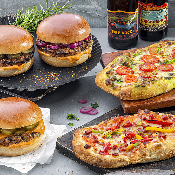 Burger und Pinsa auf Brettchen serviert